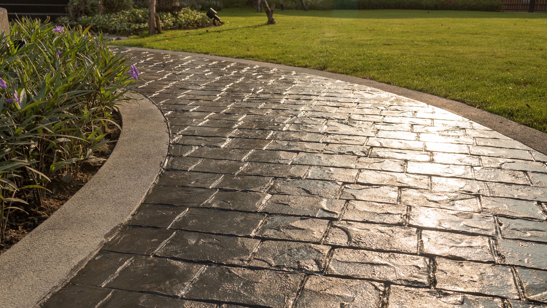 Curved stone pathway with textured pavers leading through green lawn